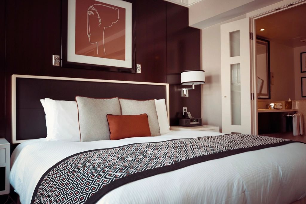 A guest room with a large bed and soft lighting